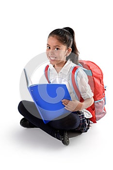 Happy latin child reading textbook or notepad smiling sitting on the floor