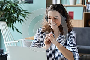 Happy latin girl student wearing headphones watching distance online class.