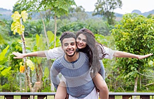 Happy Latin Man Carry Woman On Back, Young Couple Over Green Tropical Rain Forest Landscape