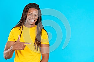 Happy latin man with dreadlocks pointing aside