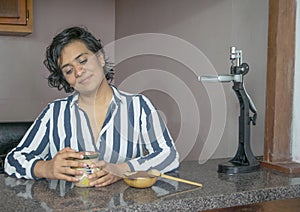 Happy latin woman with with cup of mexican coffee and ground coffee