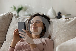 Happy Latin woman relax at home using cellphone