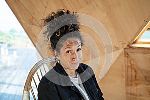 Happy Latin woman smiling while sitting indoors.