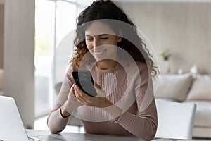 Happy Latin woman use smartphone at home