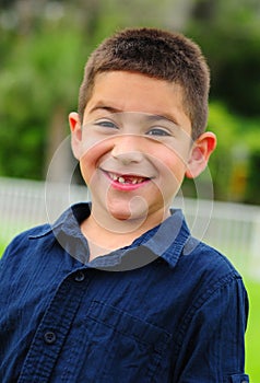 Happy latino child smiling with missing tooth