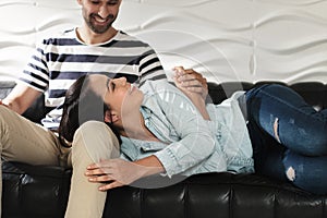 Happy Latino Couple Holding Hands And Smiling On Sofa