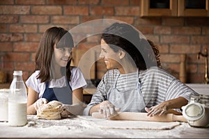 Happy Latino mom and small daughter baking at home