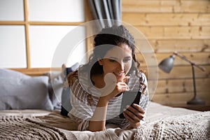 Happy Latino woman relax at home using cellphone