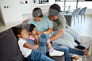 Happy, laugh and play family smile in the lounge at home. Mother, father and young children playing, having fun and