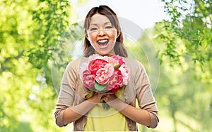 Happy laughing asian woman with bunch of flowers