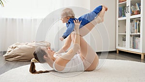 Happy laughing baby boy having fun with mother doing fitness exercises on floor. Family healthcare, active lifestyle, parenting