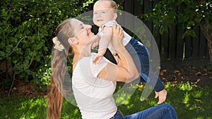 Happy laughing baby boy with mother having fun and playing in garden. Parenting, family, children development, and fun