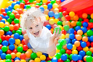 Child playing in ball pit on indoor playground photo