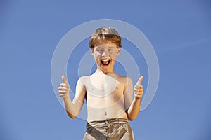 Happy and laughing boy posing thumbs up