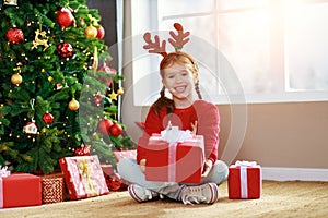 Happy laughing child girl with christmas present