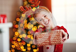 Happy laughing child girl with christmas present