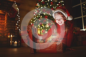 Happy laughing child girl with magic gift on Christmas Eve