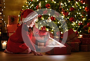 Happy laughing child girl with magic gift on Christmas Eve