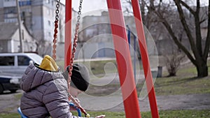 Happy, Laughing Child Swinging on a Swing in the Yard Without Friends