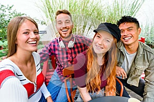 Happy laughing diverse group of young friends taking a selfie