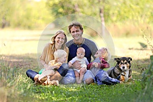 Happy Laughing Family of 5 People and Dog in Sunny Garden