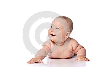 Happy laughing, giggling infant child baby girl kid in diaper is lying on her tummy holding arm outstretched