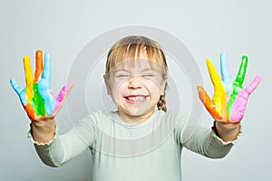 Happy laughing girl art school student showing her colorful painted hands on white background