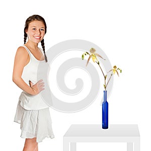 Happy laughing girl, a blue vase with a beautiful flower is standing on a table beside the model