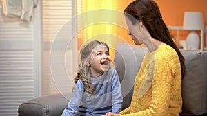 Happy laughing girl telling smiling mommy funny stories, trustful relations photo