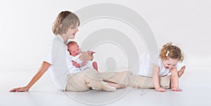 Happy laughing kids playing together in white room