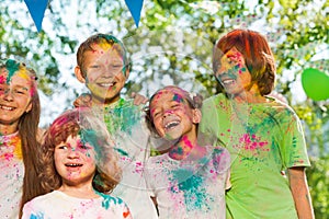 Happy laughing kids smeared with colored powder