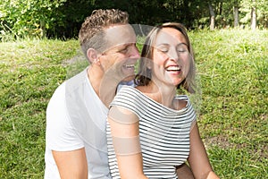 Happy laughing lovely young couple in love spending time outdoors summer day