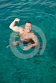 Happy laughing man posing in the water