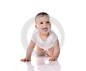 Happy laughing screaming toddler baby in diaper and white bodysuit is crawling on all fours looking at upper corner