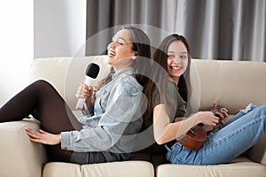 Happy laughing sisters on the couch in the living room