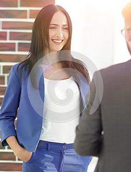 Happy laughing young businesswoman sharing a joke with a male co