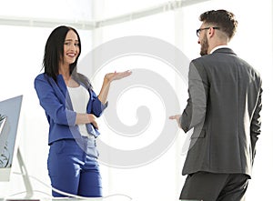 Happy laughing young businesswoman sharing a joke with a male co