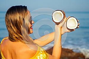 Happy and laughing young girl holding coconuts.woman with coconut on tropical island on shore beach.exotic spa resort
