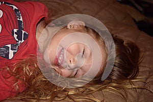 Happy laughing young girl jumping on the bed