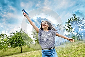 Happy laughing young girl trailing a smoke flare