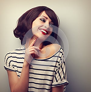 Happy laughing young short hairstyle woman in fashion blouse touching neck