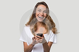 Happy laughing young woman using cellphone apps, having fun