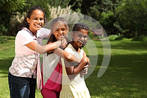 Happy laughter and hugs from three school friends