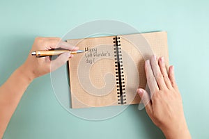 Happy Left Hander& x27;s Day. Left hand hold pen and writing text. photo