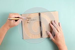 Happy Left Hander& x27;s Day. Left hand hold pen and writing text. photo