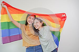 Happy lesbian, beautiful asian young two women, girl gay, couple love moment spending good time together, holding or waving lgbt