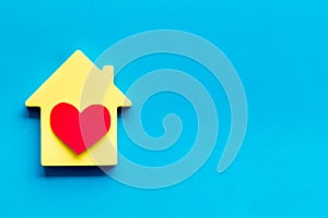 Happy life and home concept. House cutout and heart icon on blue background top view copy space