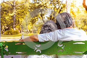 Happy life and long lived concept. At the end of life, older couple sitting together on bench at a park. Grandfather or older