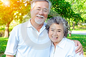 Happy life and long lived concept. Handsome old man and beautiful old woman embracing together, look at camera. Older couple have