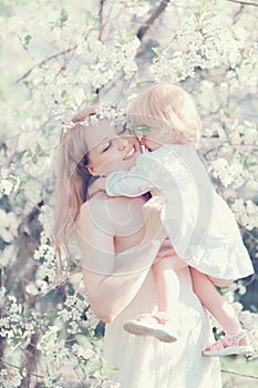 Happy life moments mother hugging child in sunny spring